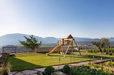 a playground with a slide in a garden at Mederle Hof in Appiano sulla Strada del Vino