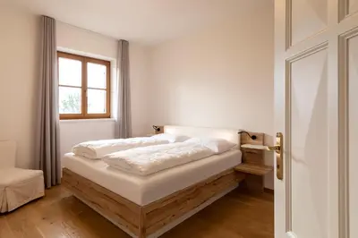 a bedroom with a bed and a window at Mederle Hof in Appiano sulla Strada del Vino