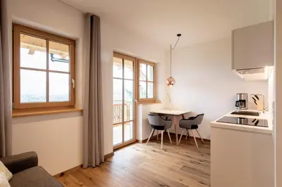 a living room with a kitchen and a table with chairs at Mederle Hof in Appiano sulla Strada del Vino