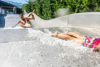 two young people playing on a water slide at Hotel Prokulus - Family & Wellness in Naturno