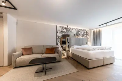 a bedroom with a bed and a couch at Hotel Prokulus - Family & Wellness in Naturno