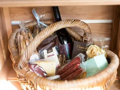 a basket filled with cheese and meats and wine at Hotel Weingut Innerleiterhof in Schenna