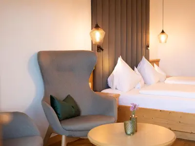a hotel room with a chair and a bed at Hotel Weingut Innerleiterhof in Schenna