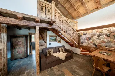 a living room with a couch and a staircase at Camping Catinaccio Rosengarten in Pozza di Fassa