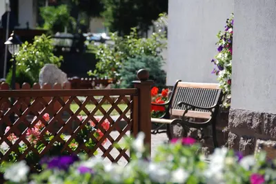 a wooden fence with a bench and flowers at Hotel Ciampian in Moena