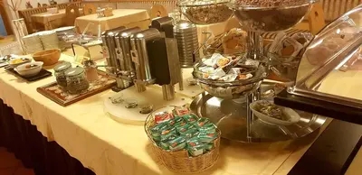 a table with a buffet with food and wine glasses at Hotel Ciampian in Moena