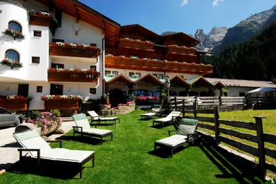 a large building in front of a mountain at Hotel Stalon Alpine Chic in San Martino di Castrozza
