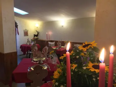 a dining room with a table with flowers and candles at Hotel Stalon Alpine Chic in San Martino di Castrozza