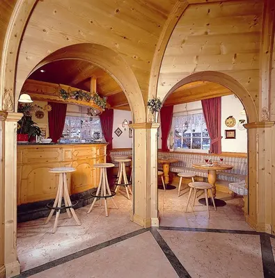 a bar with tables and chairs in a room at Hotel Garni Soreie in Pozza di Fassa