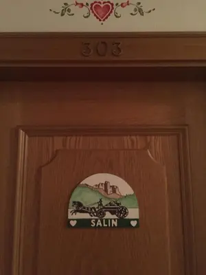 a wooden door with a sign on it at Hotel Garni Soreie in Pozza di Fassa