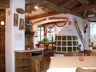 a kitchen with a table and a stove in a room at Hotel Garni Soreie in Pozza di Fassa