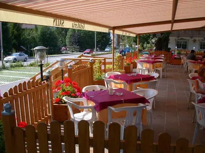 a restaurant with tables and chairs with purple table cloth at Hotel Garni Soreie in Pozza di Fassa