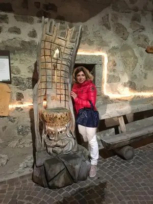 a woman is standing next to a statue at Hotel Laurino in Pozza di Fassa