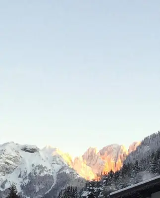 a view of a mountain range with snow at Hotel Laurino in Pozza di Fassa