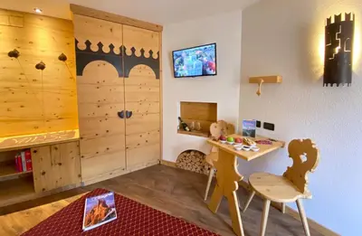a childs room with a desk and a table and chair at Hotel Laurino in Pozza di Fassa