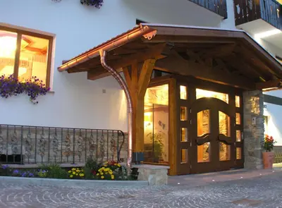 a entrance to a house with a wooden entrance door at Hotel Laurino in Pozza di Fassa