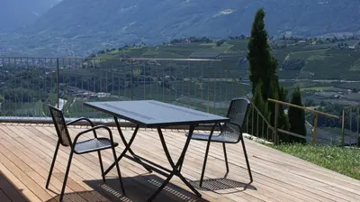 a table and two chairs sitting on a wooden deck at Residence Fiegl in Schenna