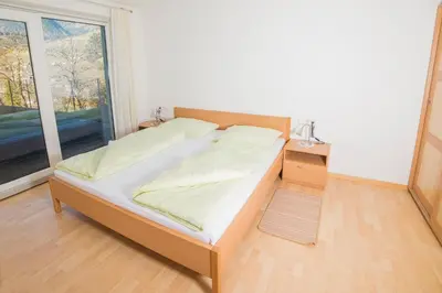 a bed in a room with a large window at Residence Fiegl in Schenna