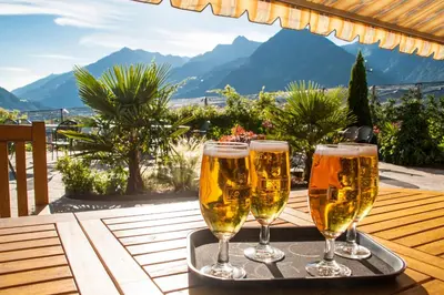 three glasses of beer on a tray on a table at Pension Obertaberhof in Schenna