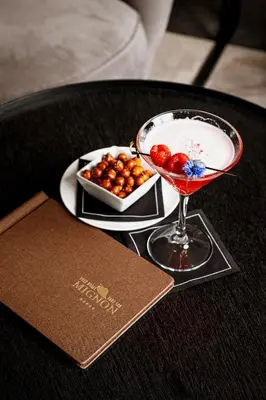 a drink in a martini glass next to a plate of balls at Hotel Mignon Meran Park & Spa in Merano