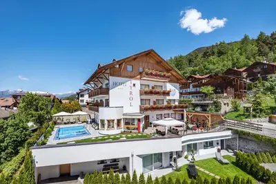 a house in the mountains with a swimming pool at Hotel Tyrol Plose in Bressanone