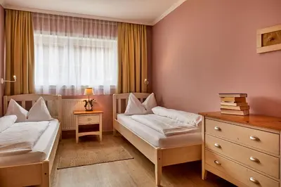 a bedroom with two beds and a window at Appartamenti La Sajun & Les Viles in La Villa