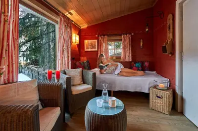 a woman is sitting on a bed in a room at Appartamenti La Sajun & Les Viles in La Villa