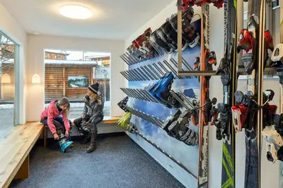 two people in a room with skis on the wall at Appartamenti La Sajun & Les Viles in La Villa