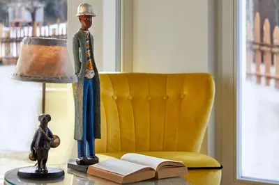 a statue of a man on a table with a lamp and a book at Appartamenti La Sajun & Les Viles in La Villa