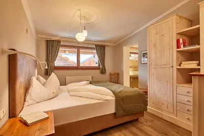 a bedroom with a bed and a window at Appartamenti La Sajun & Les Viles in La Villa
