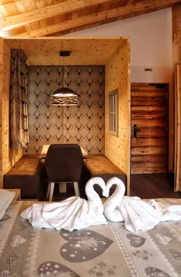 two swans laying on a bed in a room at Hotel Panorama Wellness & Resort in Malosco