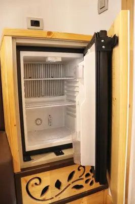 an empty refrigerator with its door open in a room at Hotel Panorama Wellness & Resort in Malosco