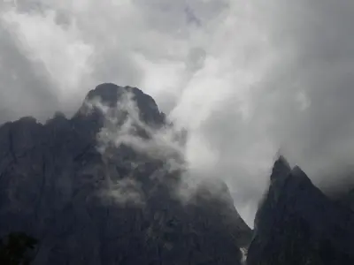 a mountain covered in fog and clouds on top of it at B&B DOLOMIA in Sagron Mis