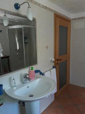 a bathroom with a white sink and a mirror at B&B DOLOMIA in Sagron Mis