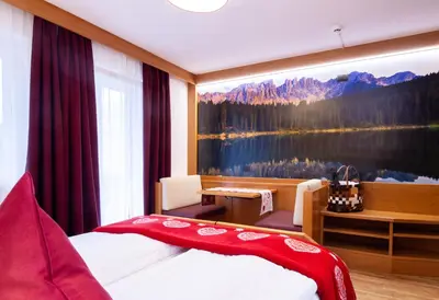 a hotel room with a large painting of a lake at Hotel Cirelle Suite & Spa in Canazei