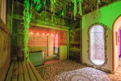 a bathroom with a bench in a room with green lighting at Residence Cirelle Suite & Spa in Canazei
