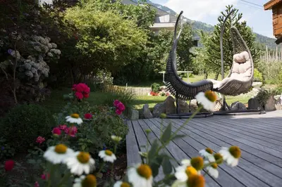a statue of a bird sitting on a swing in a garden at LINGHOF in Tirolo