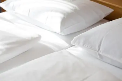 a pile of white pillows on a bed at LINGHOF in Tirolo