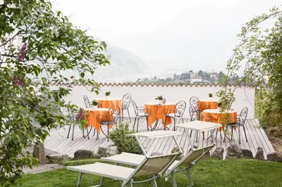 a group of tables and chairs next to a body of water at LINGHOF in Tirolo