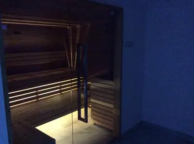 a dark room with a glass door to a sauna at Hotel Silvana in Selva di Val Gardena