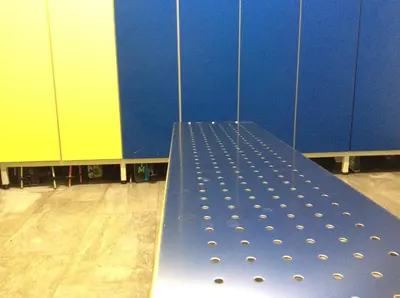 a blue bench in a gym with a blue wall at Hotel Silvana in Selva di Val Gardena