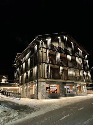 a building with lights on the side of it at night at Hotel Silvana in Selva di Val Gardena