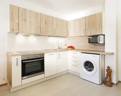 a kitchen with a washing machine and a microwave at Apartments Cesa Bruma in Ortisei