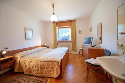 a bedroom with a bed and a sink at Apartments Cesa Bruma in Ortisei