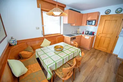 a small kitchen with a table and a table and chairs at Apartments Cesa Bruma in Ortisei