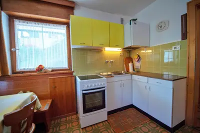 a kitchen with white cabinets and a stove top oven at Apartments Cesa Bruma in Ortisei