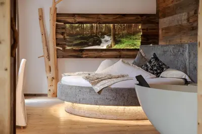 a bedroom with a bed in a room with a window at Bio Boutique Hotel Laurino in Cavalese