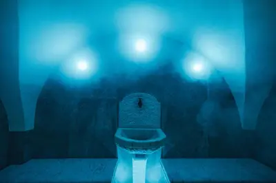 a dark bathroom with a toilet with blue lights at Bio Boutique Hotel Laurino in Cavalese