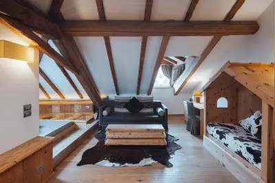 a living room with a couch in the attic at Bio Boutique Hotel Laurino in Cavalese