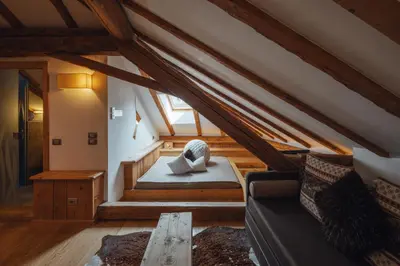 a attic room with a couch and a table at Bio Boutique Hotel Laurino in Cavalese